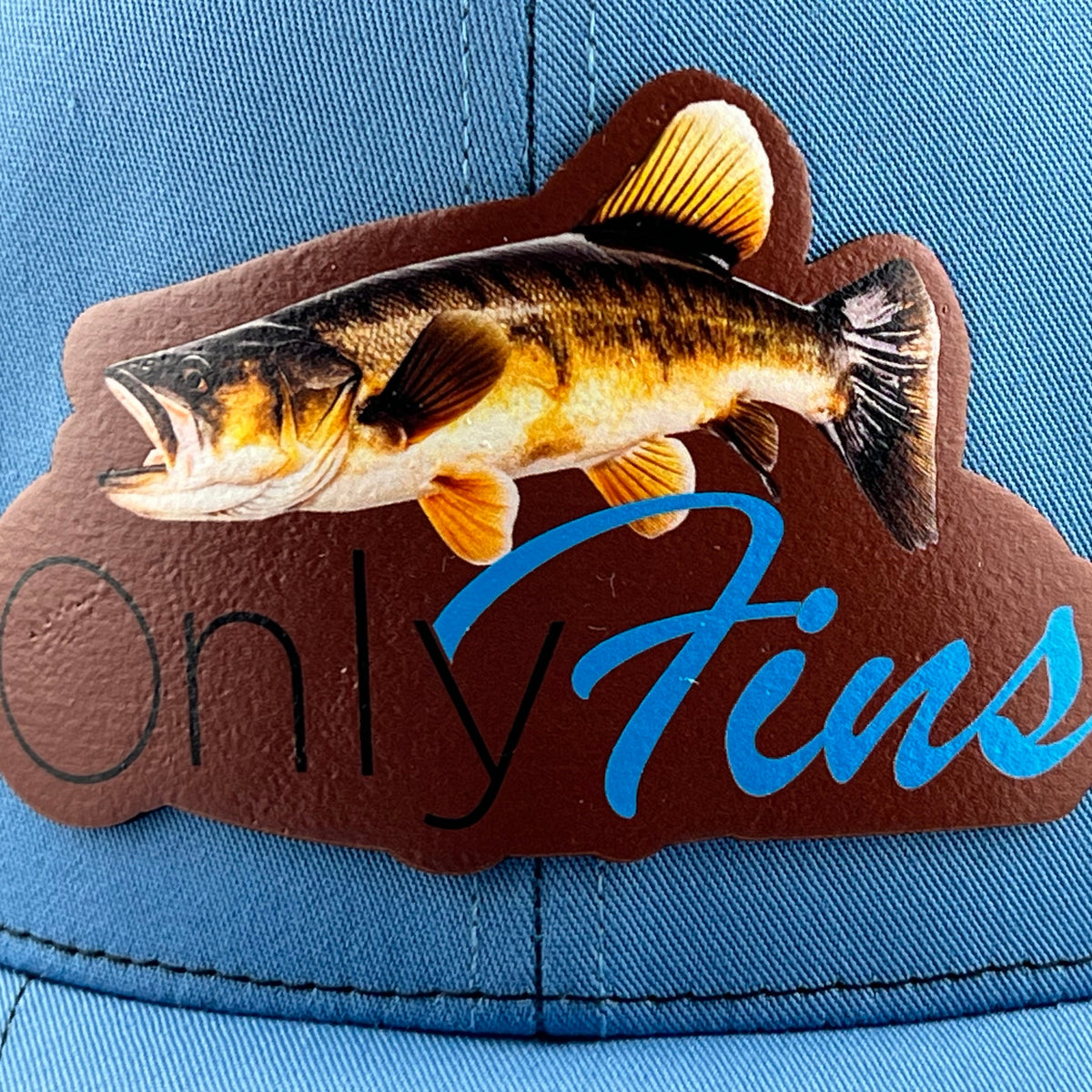 Close-up of the Only Fins walleye leather patch on a Columbia blue cap