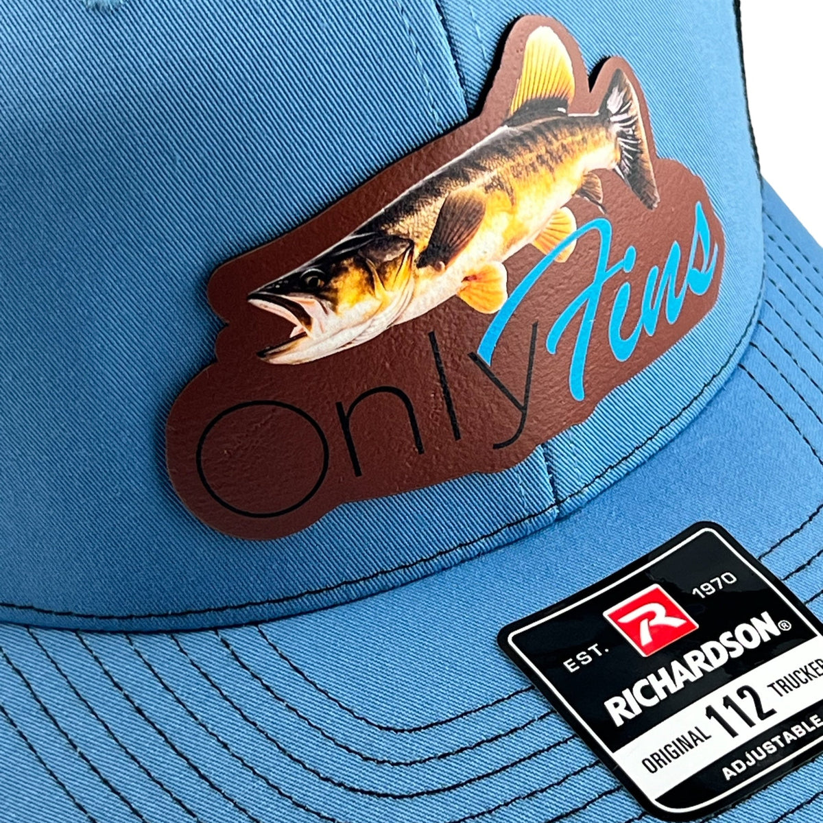 Angled view of the Only Fins walleye patch next to the Richardson 112 tag