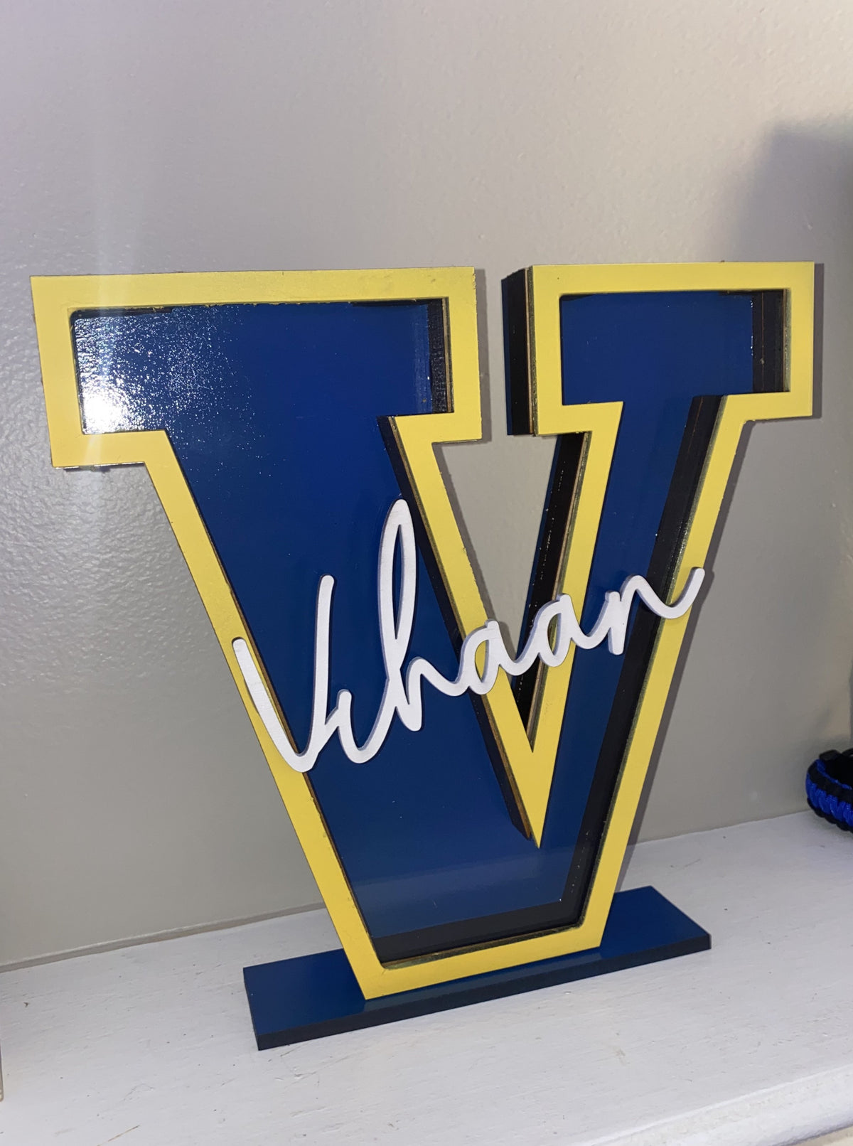 Blue letter V custom name piggy bank with yellow trim and the name Vihaan by HSTORM Printing
